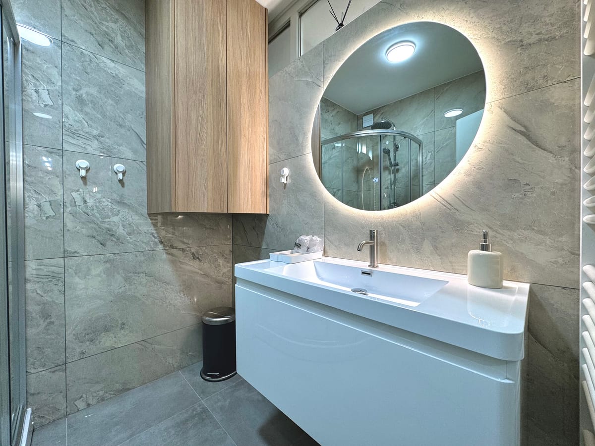 Bathroom with shower cabin and backlit mirror