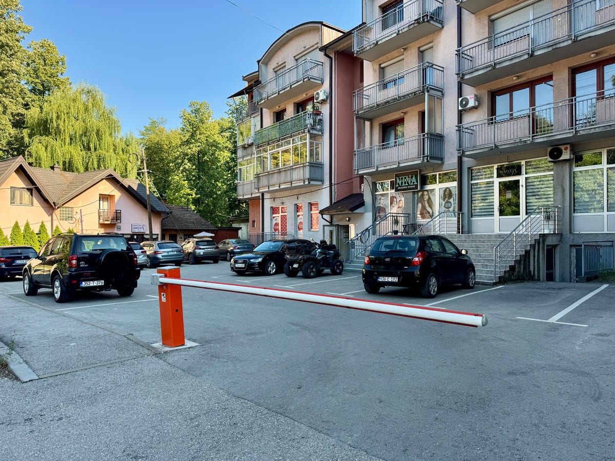 Private parking in front of the building, with a barrier